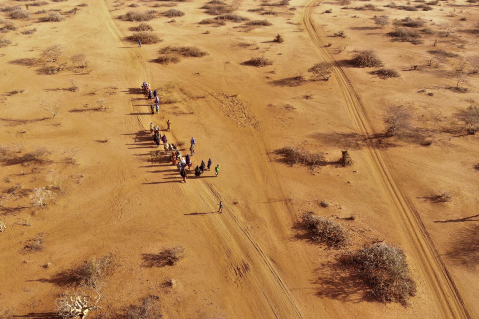 Personas que le escapan a una sequía caminando en medio del desierto se acercan a un campamento para desplazados en las afueras de Dollow (Somalia) el 21 de septiembre del 2022. (AP Photo/Jerome Delay).