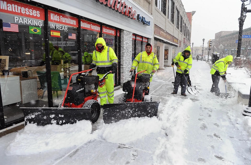 A snow-clearing crew is hard at work in downtown Framingham during a storm in January 2022. With spring just a week away, forecasters are calling for at least half a foot of heavy wet snow and high winds on Tuesday.