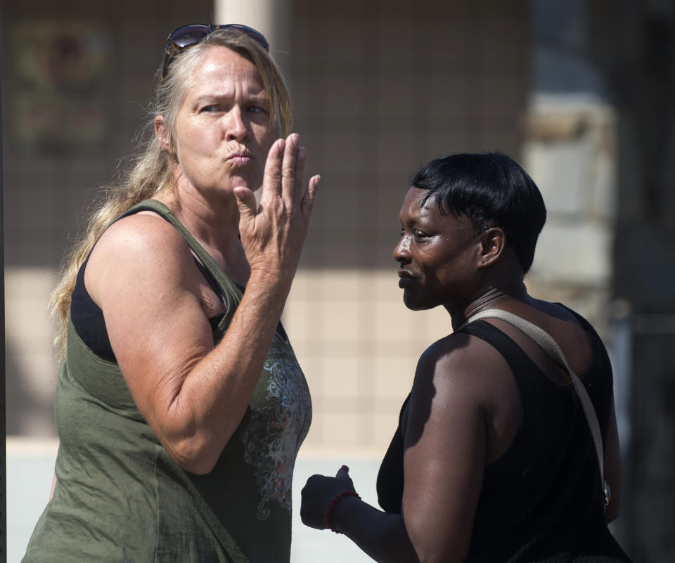 A woman blows a kiss to residents at an apartment complex, Monday, Sept. 3, 2018, in San Bernardino, Calif., where a shooting occurred during a dice game on Sunday night. (Cindy Yamanaka/The Orange County Register via AP)