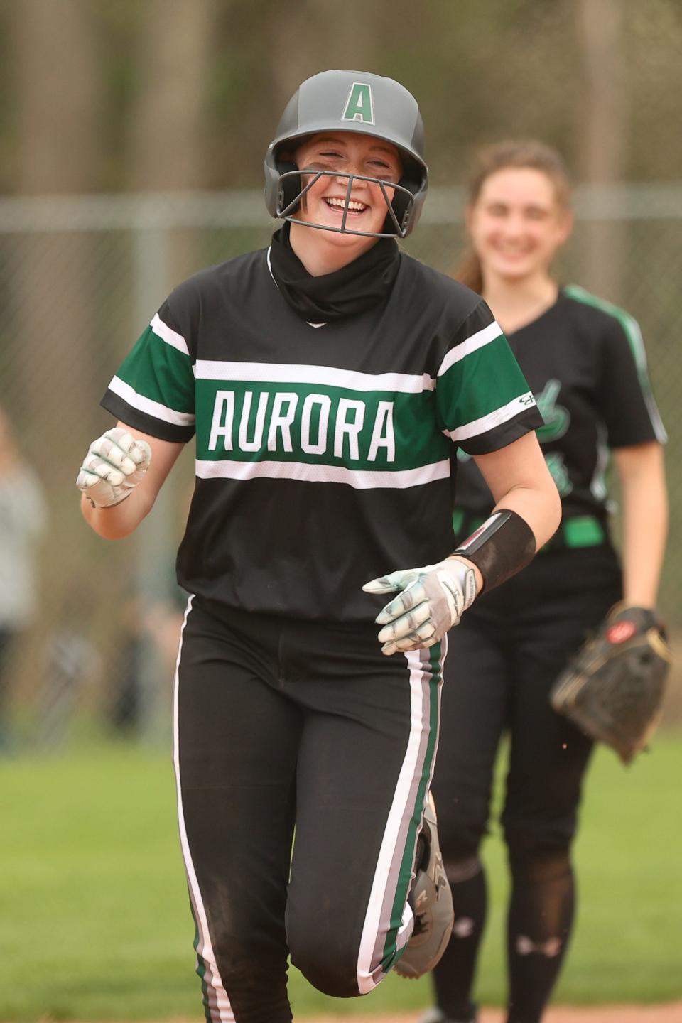 Aurora’s McKennah Metzger is all smiles as she rounds the bases on her fifth-inning home run to bring the Greenmen within one run of Highland.