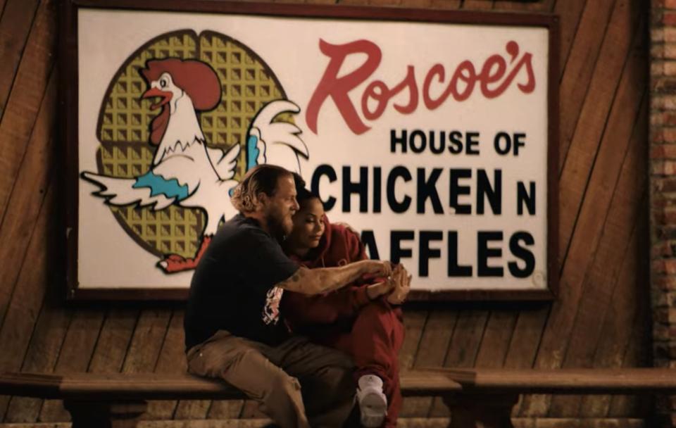 Jonah and Lauren's characters sit in front of a restaurant together