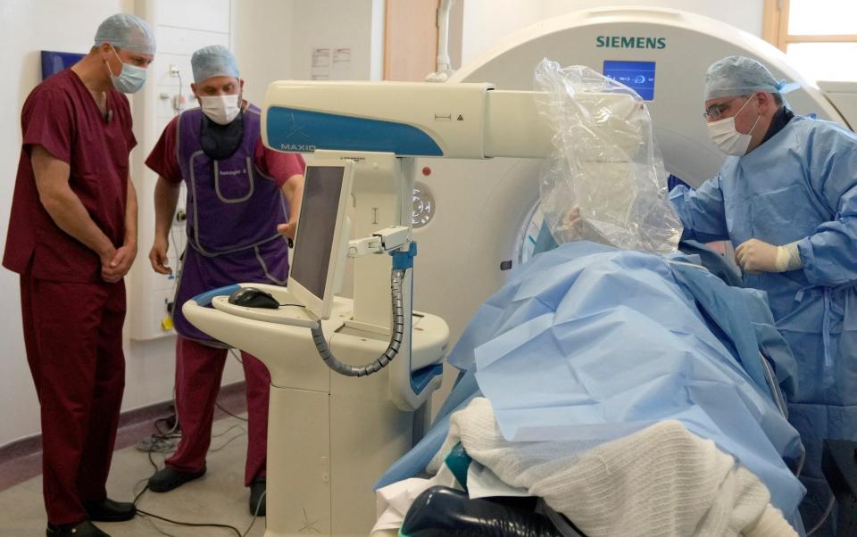 Prince William, President of The Royal Marsden NHS Foundation Trust, looks at a screen to follow the robotic microwave ablation procedure - REUTERS