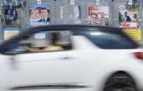 A car drives past electoral posters, Thursday, June 27, 2024 in Strasbourg, eastern France. French President Emmanuel Macron called snap elections following the defeat of his centrist alliance at European Union elections earlier this month. Voters will choose lawmakers for the National Assembly in two rounds on June 30 and July 7. (AP Photo/Jean-Francois Badias)