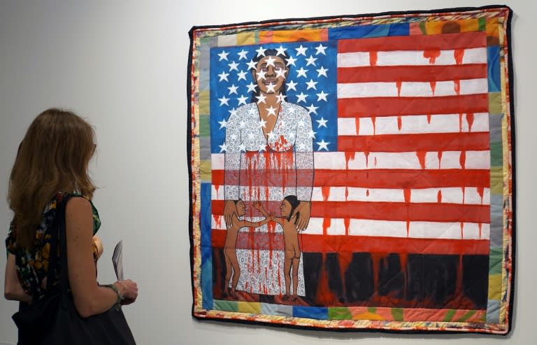 A visitor watches the work of US artist Faith Ringgold, "The Flag is Bleeding #2" (1997) in December 1997 ahead of the opening of the Art Basel international fair that takes place annually in Miami Beach (Leila MACOR)
