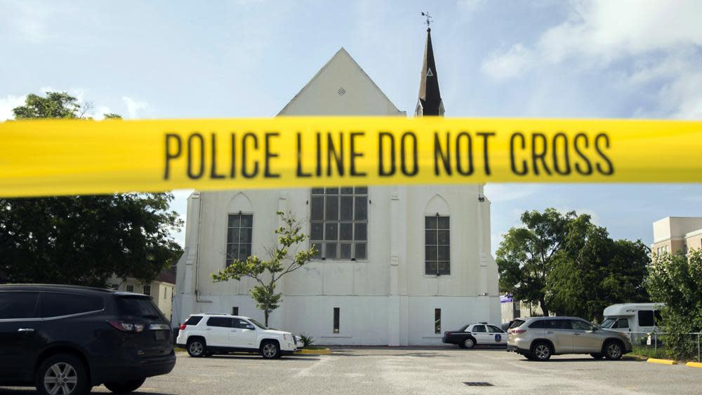 Police tape surrounds the parking lot behind the AME Emanuel Church in Charleston, S.C. on June 19, 2015, as FBI forensic experts work at the crime scene of the racist fatal shooting of nine members of the Black congregation. (AP Photo/Stephen B. Morton, File)