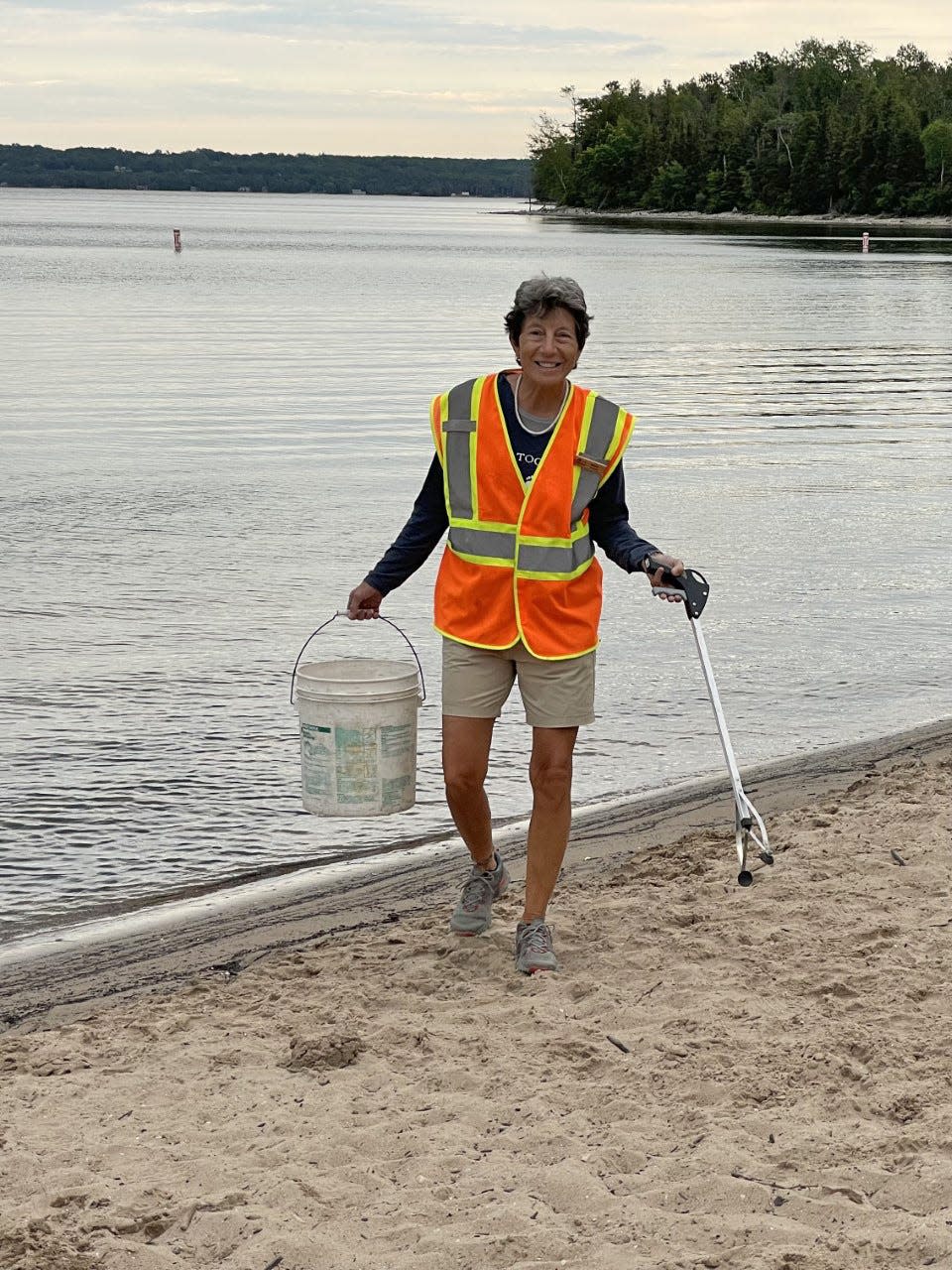 Heidi Wasson cleans up trash along a beach at Peninsula State Park while volunteering as a camp host there in the summer of 2022.