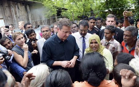 Britain's Prime Minister David Cameron talks with Tamil people at the Sabapathi Pillay Welfare Centre in Jaffna, about 400 km (250 miles) north of Colombo November 15, 2013. REUTERS/Stringer
