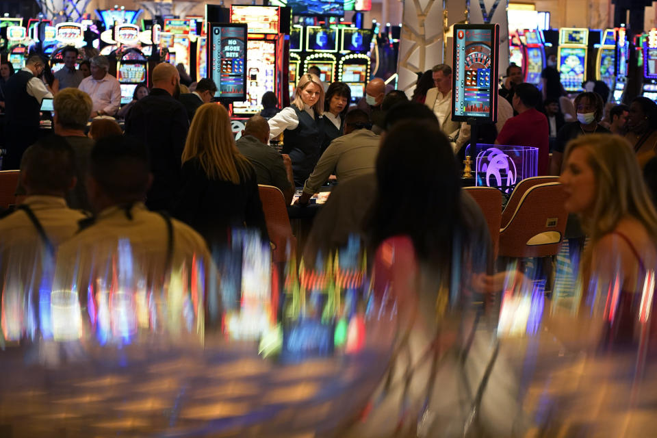 FILE - In this June 24, 2021, photo, visitors crowd the casino during the opening night of the Resorts World Las Vegas hotel-casino in Las Vegas. Nevada casinos reported near-record March 2022 house winnings, while the airport in Las Vegas reported passenger traffic almost as heavy as pre-pandemic levels and tourism officials marked another big jump in visitor volume. (AP Photo/John Locher, File)