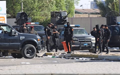 Iraqi security forces stand guard outside the interior ministry during a demonstration  - Credit: AFP