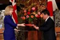 Britain's International Trade Secretary Elizabeth Truss and Japanese Foreign Minister Toshimitsu Motegi sign the UK-Japan Comprehensive Economic Partnership Agreement in Tokyo