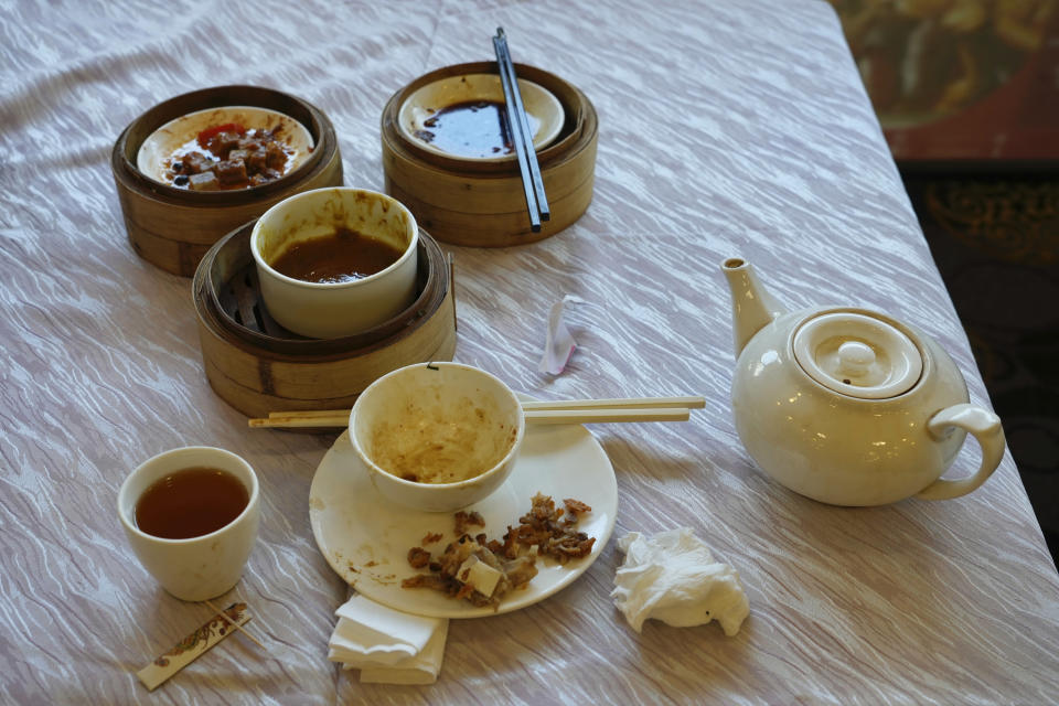 A finished meal at sits on the table at the Fung Shing Restaurant which will be closing on February 20 after 20 years in Hong Kong, Tuesday, Feb. 15, 2022. Despite the strict adherence to a zero-COVID strategy, restrictions in Hong Kong that have already stilled the once bustling city, now many fear the worst is yet to come, with Hong Kong experiencing its worst outbreak yet. (AP Photo/Vincent Yu)