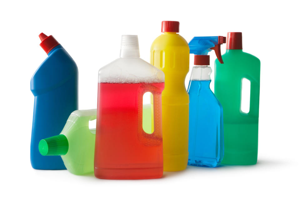 Five different household cleaning product containers against a white background