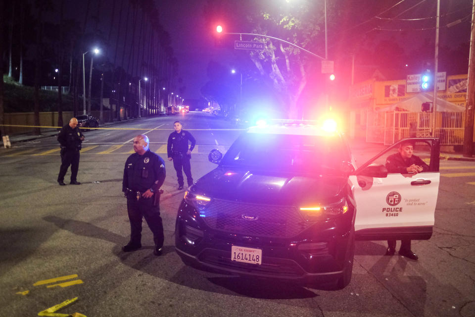 Police officers stand guard near a crime scene where three Los Angeles police officers were shot, Wednesday, March 8, 2023, in Los Angeles. Police said the officers were hospitalized and in stable condition. (AP Photo/Ringo H.W. Chiu)