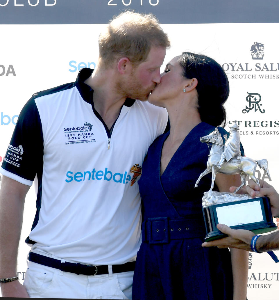 WINDSOR,  UNITED KINGDOM - JULY 26:    Meghan, Duchess of Sussex and Prince Harry, Duke of Sussex kiss as they pose with the trophy after the Sentebale ISPS Handa Polo at the Royal County of Berkshire Polo Club on July 26, 2018 in Windsor, England. (Photo by Anwar Hussein/WireImage)