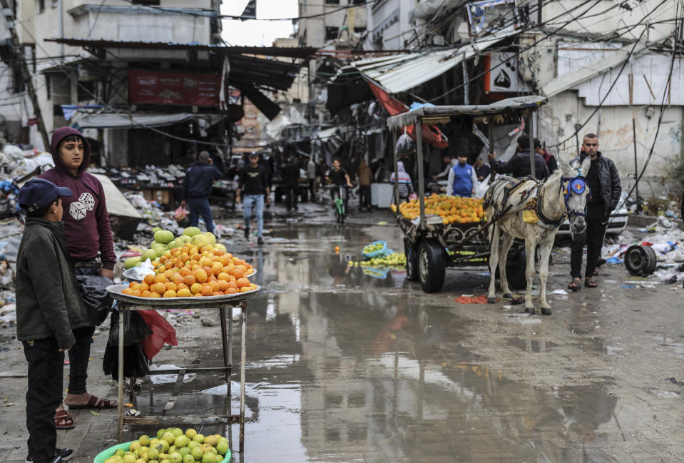 Palestinos venden frutas en la Ciudad de Gaza, el 27 de noviembre de 2023. (AP Foto/Mohammed Hajjar)