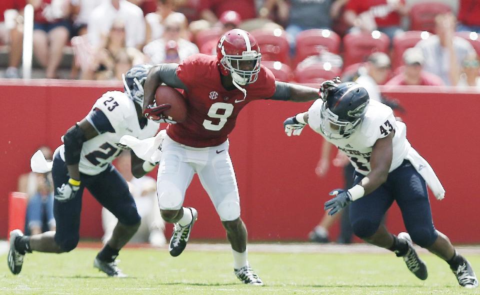 Alabama wide receiver Amari Cooper (9) stiff-arms Florida Atlantic linebacker Robert Relf (43) in the second half of an NCAA college football game Saturday, Sept. 6, 2014, in Tuscaloosa, Ala. (AP Photo/Brynn Anderson)