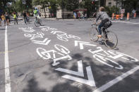 FILE - Symbols painted on the street indicate a bicycle path in Montreal on Tuesday, June 21, 2016. Montreal has been known for decades as a global innovator in urban biking and the first city in North America to develop an extensive network of physically separated on-street bicycle lanes. (Paul Chiasson/The Canadian Press via AP, File)
