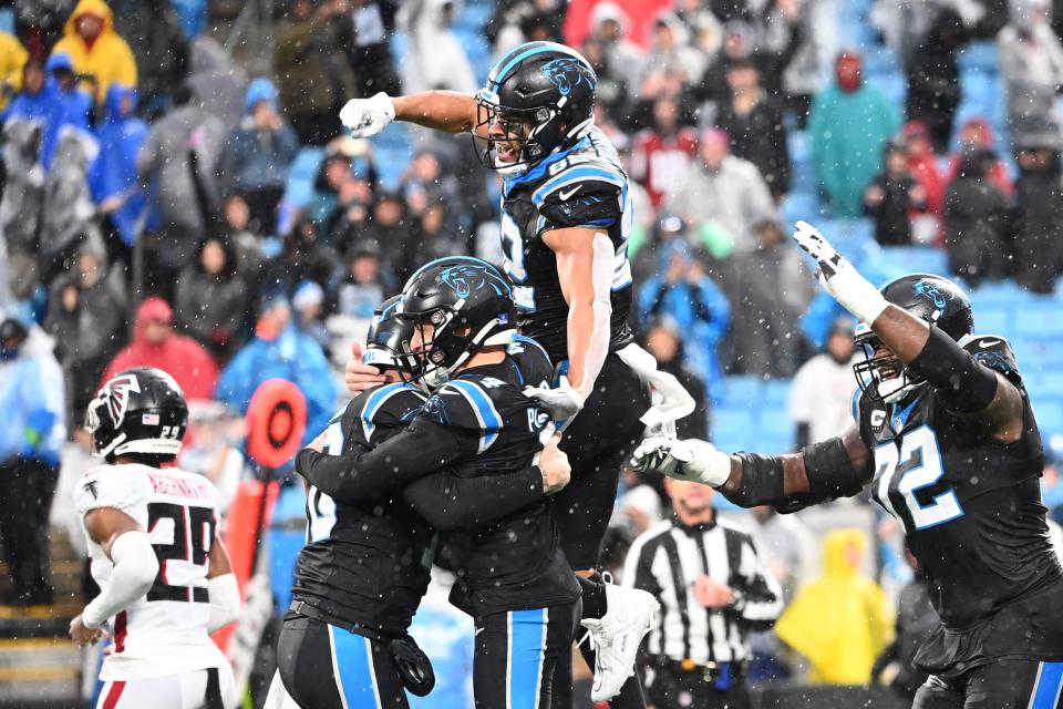 Carolina Panthers place kicker Eddy Pineiro (4) hits a game winning field goal and celebrates with punter Johnny Hekker (10) and tight end Tommy Tremble (82) and offensive tackle Taylor Moton (72) in the fourth quarter at Bank of America Stadium.