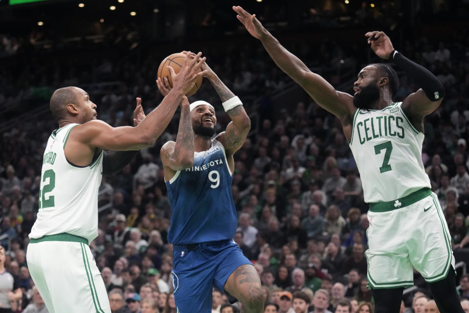 Minnesota Timberwolves guard Nickeil Alexander-Walker (9) is covered by Boston Celtics center Al Horford (42) and guard Jaylen Brown (7) on a drive to the basket during the second half of an NBA basketball game, Wednesday, Jan. 10, 2024, in Boston. (AP Photo/Charles Krupa)