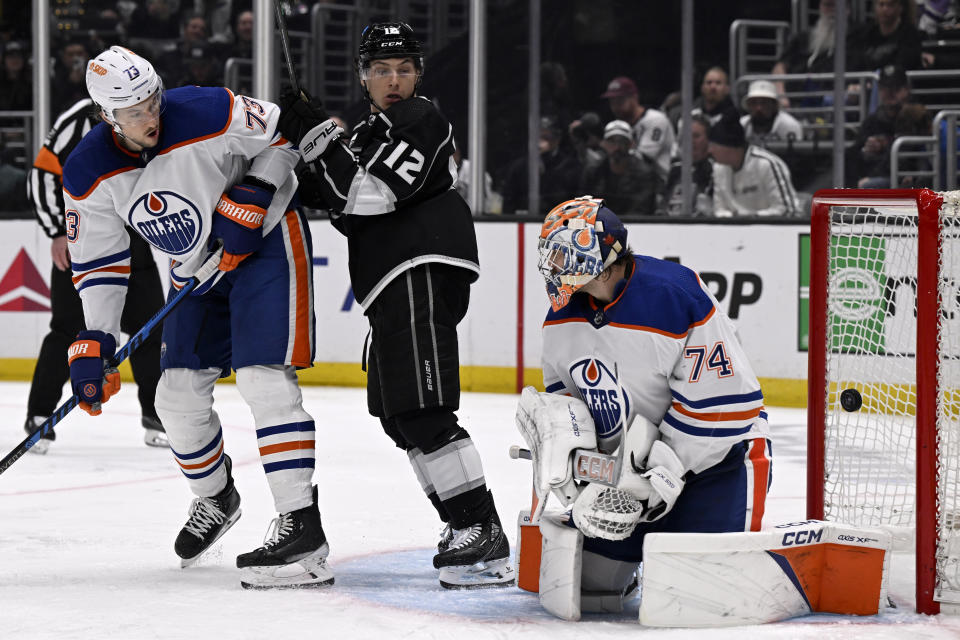 The puck gets past Edmonton Oilers goaltender Stuart Skinner (74), with defenseman Vincent Desharnais (73) and Los Angeles Kings left wing Trevor Moore (12) watching, for a goal by Kings center Pierre-Luc Dubois during the second period of an NHL hockey game in Los Angeles, Saturday, Feb. 10, 2024. (AP Photo/Alex Gallardo)