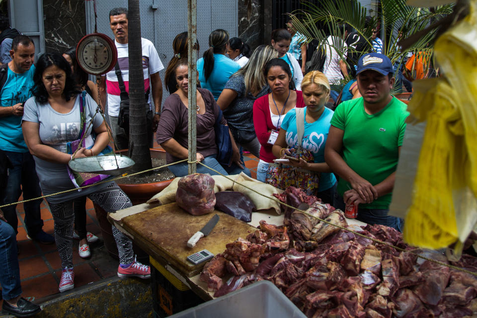 Customers stand in line to buy unregulated meat from a street vendor during a beef shortage in Caracas, Venezuela. (Photo: Getty Images)