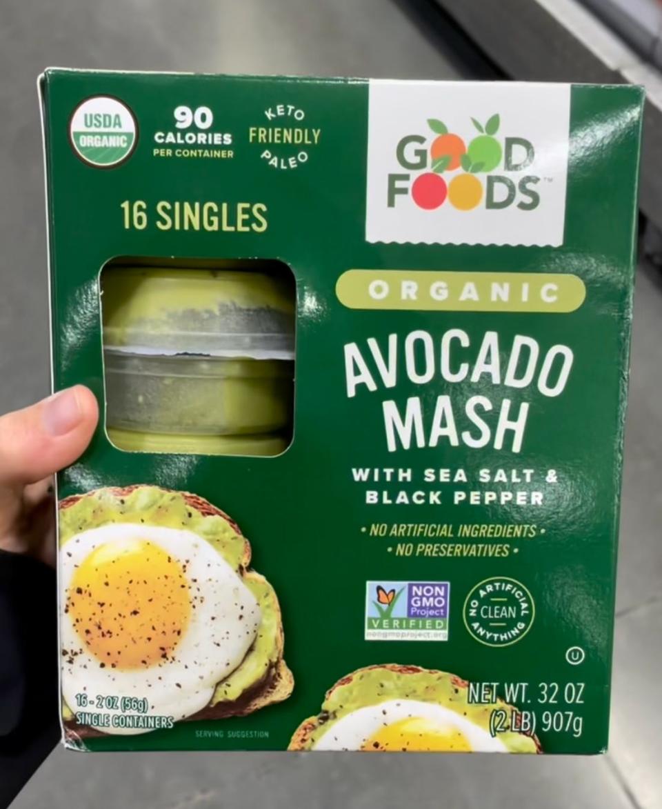 hand holding box of avocado mash at costco