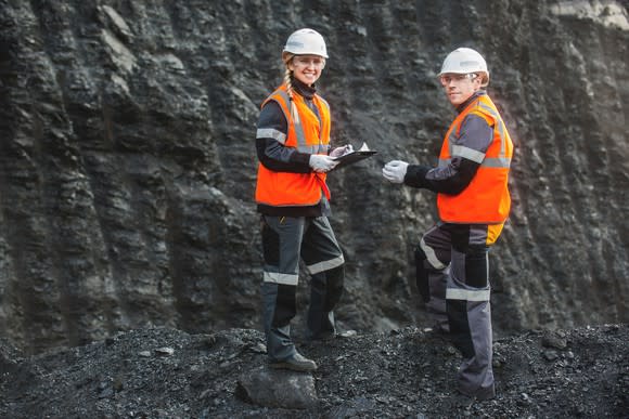 Two people standing in an open pit coal mine