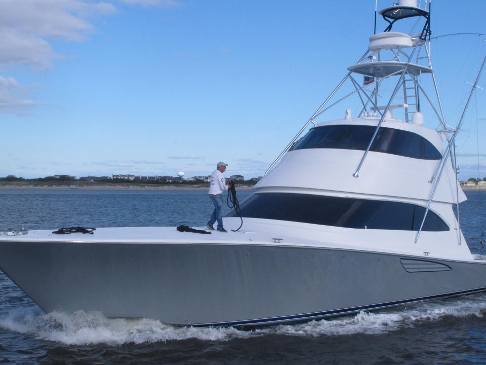 This Oct. 18, 2019 photo shows a man standing on the bow of a yacht in Atlantic City, N.J. On Oct. 22, 2019, a conference at Monmouth University in West Long Branch, N.J. examined growing competition for space out on the ocean by users including the fishing, shipping, wind energy industries and conservationists. (AP Photo/Wayne Parry)