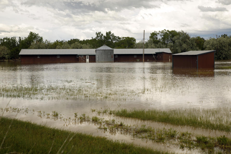 Floodwaters inundate property near the Clarks Fork Yellowstone River in between Edgar and Fromberg, Mont., on Monday, June 13, 2022. The flooding across parts of southern Montana and northern Wyoming forced the indefinite closure of Yellowstone National Park just as a summer tourist season that draws millions of visitors annually was ramping up. (AP Photo/Emma H. Tobin)