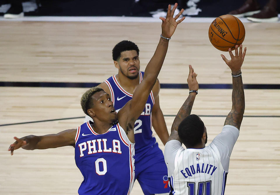 Orlando Magic's D.J. Augustin, right, scores over Philadelphia 76ers' Josh Richardson (0) during the second half of an NBA basketball game Friday, Aug. 7, 2020, in Lake Buena Vista, Fla. (Kevin C. Cox/Pool Photo via AP)