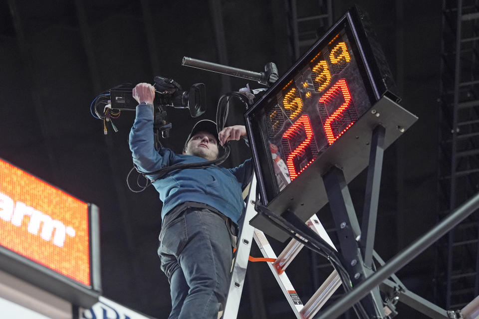 A camera that fell from above the shot clock is removed after play was stopped during the second half of an NCAA college basketball game between Texas and Houston Saturday, Feb. 17, 2024, in Houston. (AP Photo/David J. Phillip)