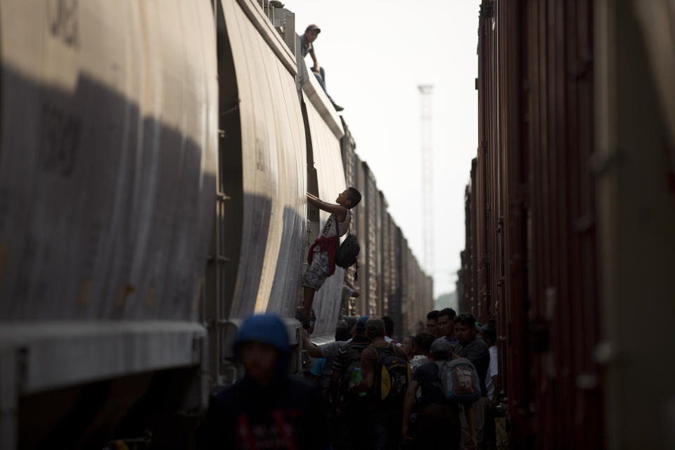 Central American migrants climb on a parked freight train during their journey toward the U.S.-Mexico border, in Ixtepec, Oaxaca State, Mexico, Tuesday, April 23, 2019. Mexican authorities started raiding the trains to pull migrants off in mid-2014 and the number of Central Americans aboard the train fell to a smattering. (AP Photo/Moises Castillo)