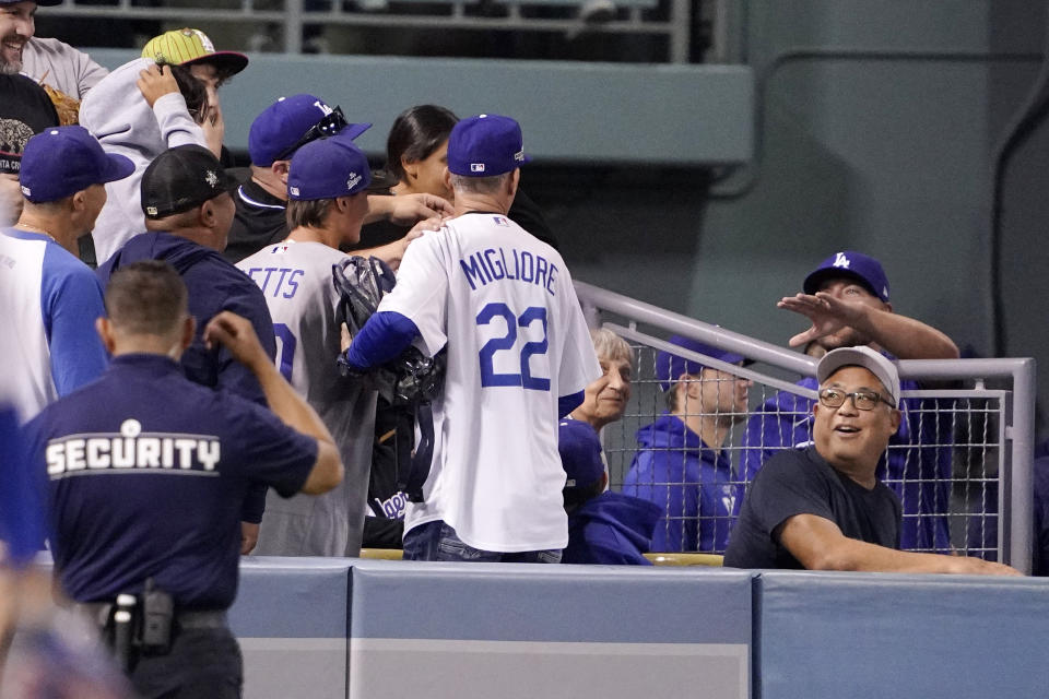 Members of the Los Angeles Dodgers talk to a fan that appeared to have interfered with a ball hit for a three-run home run by Dodgers' Chris Taylor during the fourth inning of a baseball game against the Arizona Diamondbacks Monday, Sept. 19, 2022, in Los Angeles. (AP Photo/Mark J. Terrill)
