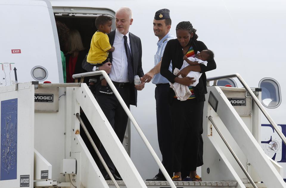 Mariam Yahya Ibrahim of Sudan (R) holds one of her children next to Lapo Pistelli (L), Italy's vice minister for foreign affairs, holding her other child, as they land at Ciampino airport in Rome July 24, 2014. The Sudanese woman who was spared a death sentence for converting from Islam to Christianity and then barred from leaving Sudan flew into Rome on Thursday. REUTERS/Remo Casilli (ITALY - Tags: RELIGION POLITICS CRIME LAW TPX IMAGES OF THE DAY)