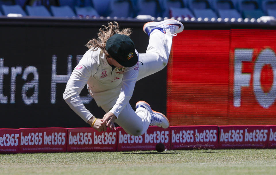 Australia's Will Pucovski is airborne as he fields the ball during play on the final day of the third cricket test between India and Australia at the Sydney Cricket Ground, Sydney, Australia, Monday, Jan. 11, 2021. (AP Photo/Rick Rycroft)