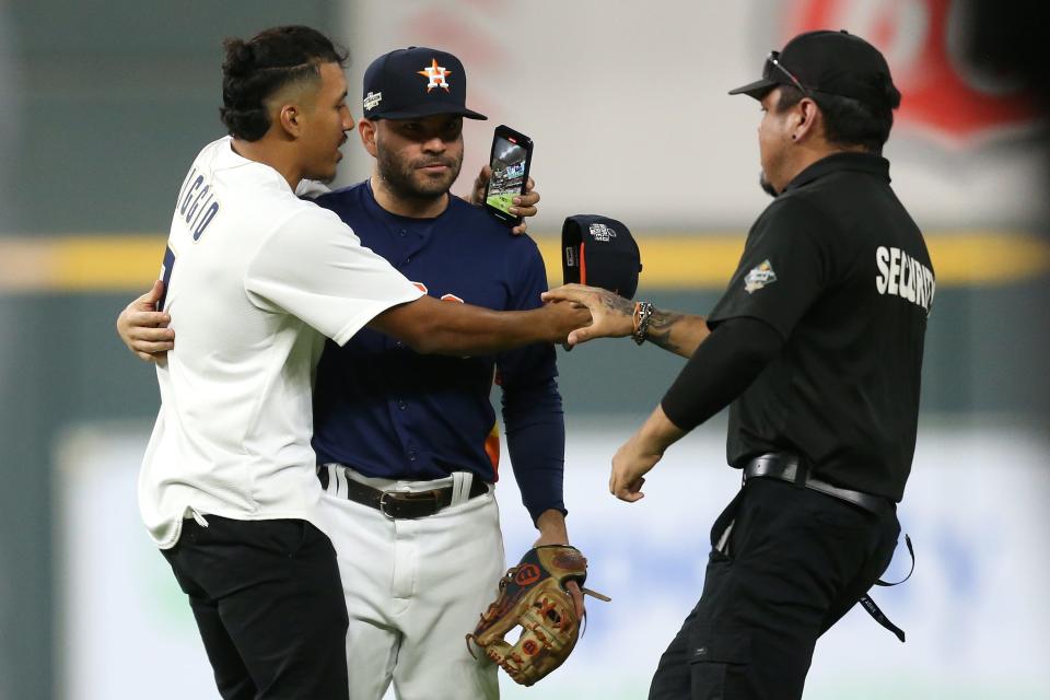 Astros second baseman Jose Altuve is approached by a fan who ran into the field.