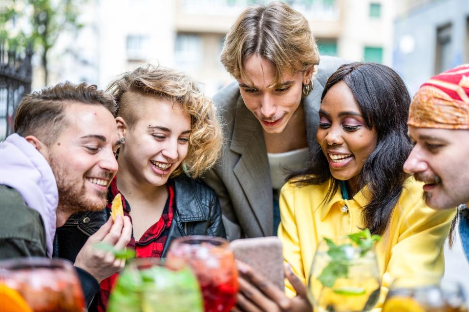 Friends looking smartly at a smartphone together.