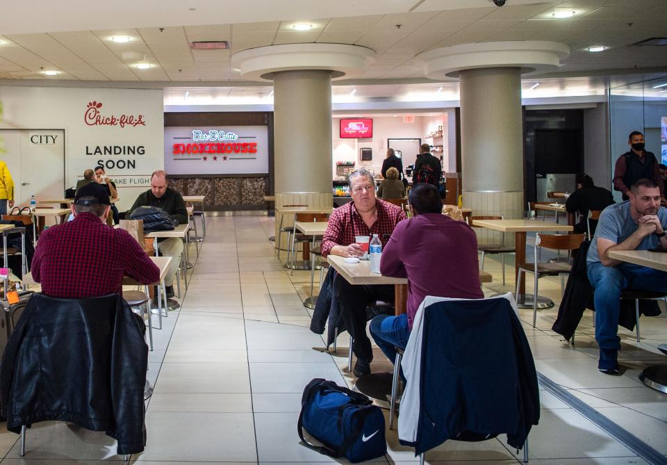 Customers eat in front of the Bar-B-Cutie chain restaurant in the BNA airport in Nashville, Wednesday, Nov. 10, 2021.