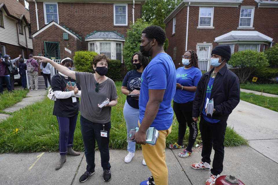 Volunteers meet before fanning out to place flyers on homes in Detroit, Tuesday, May 4, 2021. Officials are walking door-to-door to encourage residents of the majority Black city to get vaccinated against COVID-19 as the city's immunization rate lags well behind the rest of Michigan and the United States. (AP Photo/Paul Sancya)