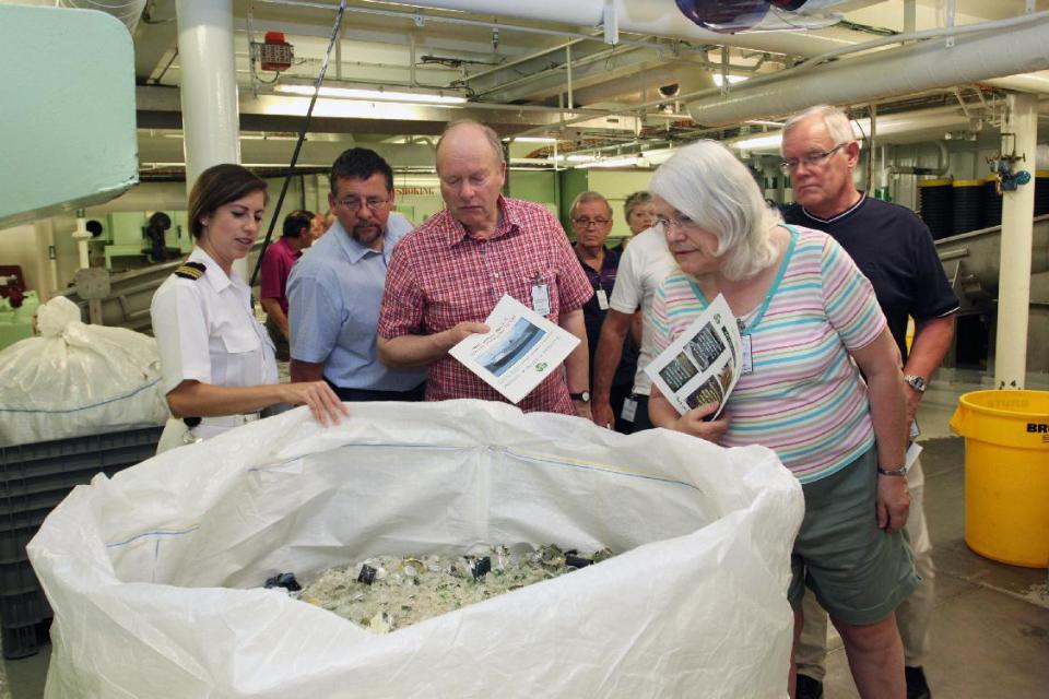 This undated image from Cunard shows passengers on the Queen Mary 2 looking into a recycling bin in the waste-handling facility of the ship. Cunard is offering back of the house tours where passengers can look at areas that are normally off-limits to guests, from the galley to the engine room. The tours are among a number of new attractions and activities being offered onboard ships as the 2013 cruise season gets under way. (AP Photo/Cunard)