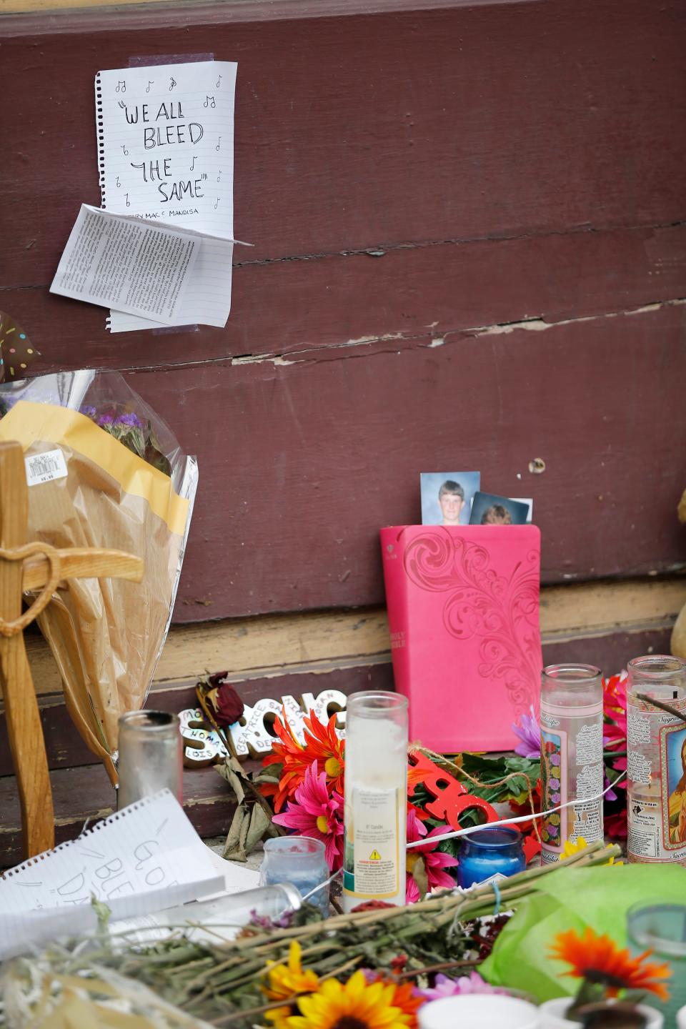 Flowers and candles are laid at the scene of a mass shooting in the Oregon District of Dayton, Ohio, on Tuesday, Aug. 6, 2019.