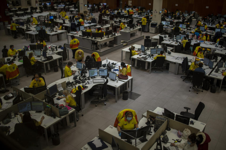 Health personnel work at the headquarters of the Emergency Medical System (SEM) in Barcelona that coordinates emergencies during the COVID-19 virus outbreak in Catalonia, Spain, Monday, April 6, 2020. Spanish Prime Minister Pedro Sánchez Sánchez announced that he would ask the Parliament to extend the state of emergency by two more weeks, taking the lockdown on mobility until April 26. The new coronavirus causes mild or moderate symptoms for most people, but for some, especially older adults and people with existing health problems, it can cause more severe illness or death. (AP Photo/Emilio Morenatti)