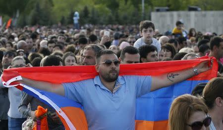 A man holds an Armenian flag as he queues to commemorate the 103rd anniversary of mass killing of Armenians by Ottoman Turks, at the Tsitsernakaberd Memorial Complex in Yerevan, Armenia April 24, 2018. REUTERS/Gleb Garanich