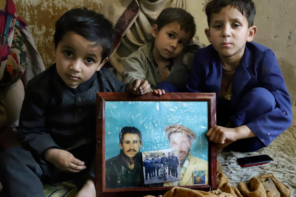 Mohammad Hassan's children hold a photo of their father.