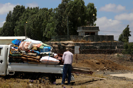 An internally displaced man stands near belongings in front of a U.N. location near the Israeli-occupied Golan Heights in Quneitra, Syria June 29, 2018. REUTERS/Alaa Al-Faqir