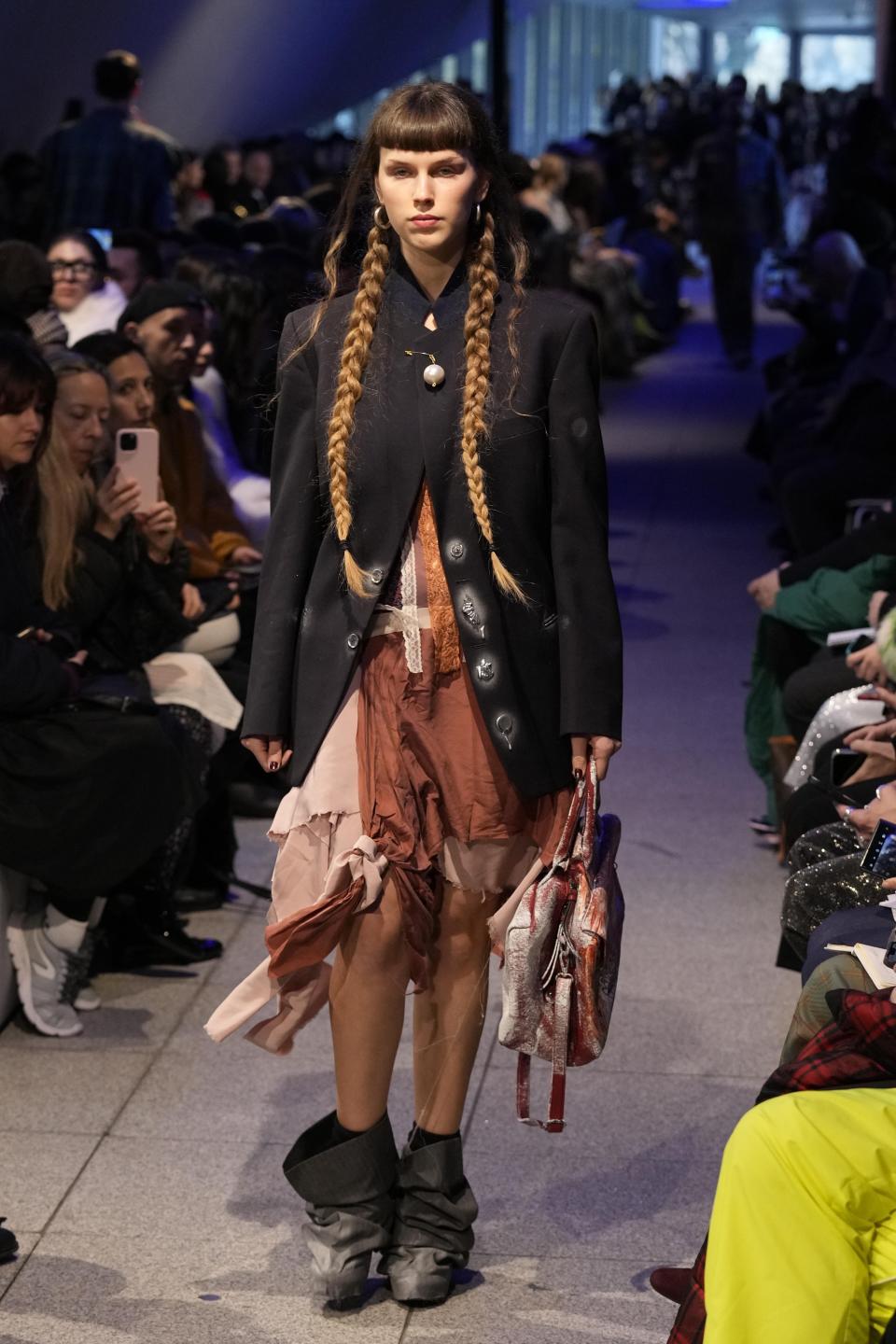 A model wears a creation part of the men's Simon Cracker Fall-Winter 2024-2025 collection, that was presented in Milan, Italy, Sunday, Jan. 14, 2024. (AP Photo/Antonio Calanni).