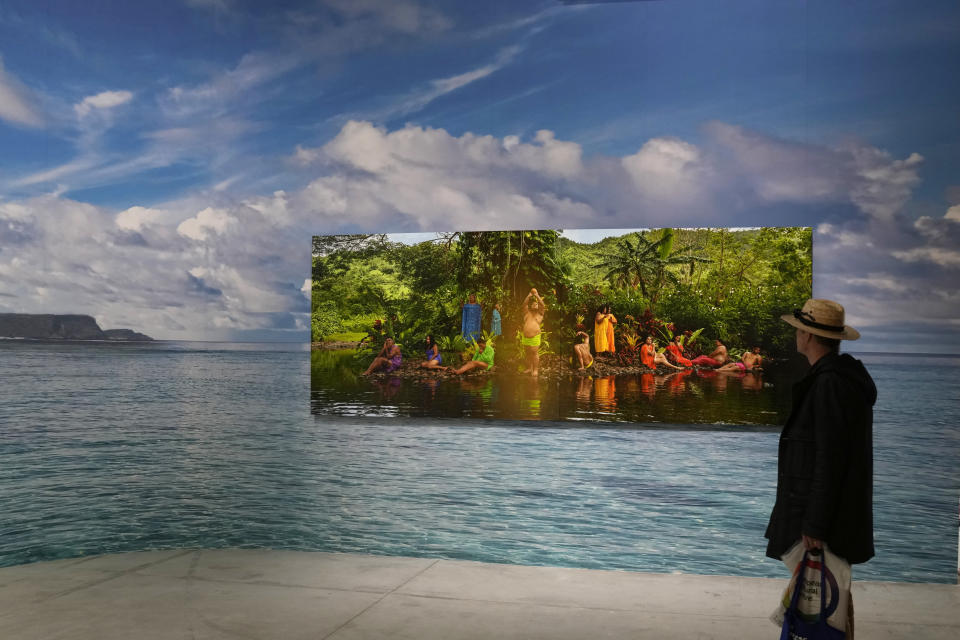 A man looks at the installation "Paradise Camp" by artist Yuki Kihara at New Zealand's pavilion during the 59th Biennale of Arts exhibition in Venice, Italy, Tuesday, April 19, 2022. (AP Photo/Antonio Calanni)