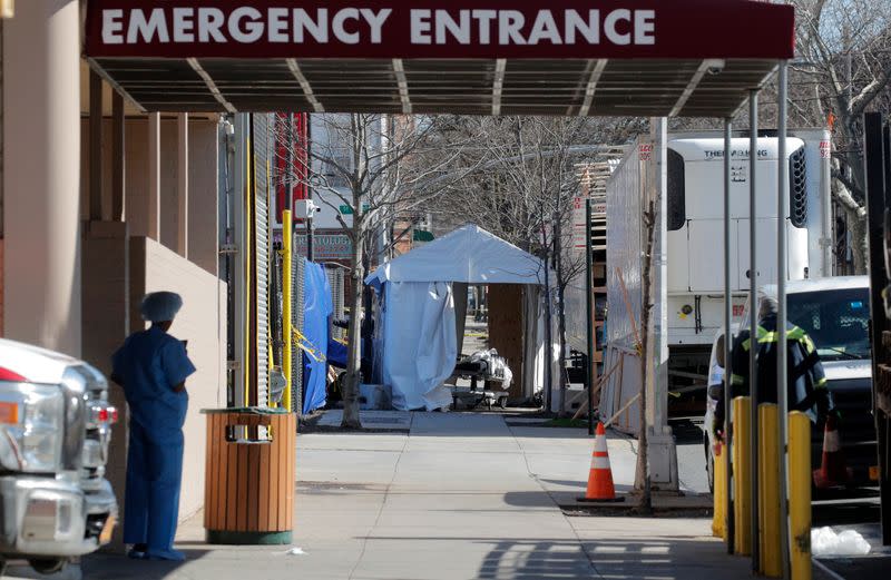 Healthcare worker looks at makeshift morgue outside Wyckoff Heights Medical Center during outbreak of coronavirus disease (COVID-19) in New York