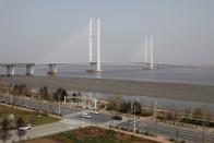 Cars travel past the New Yalu River Bridge designed to connect China's Dandong New Zone and North Korea's Sinuiju, in Dandong