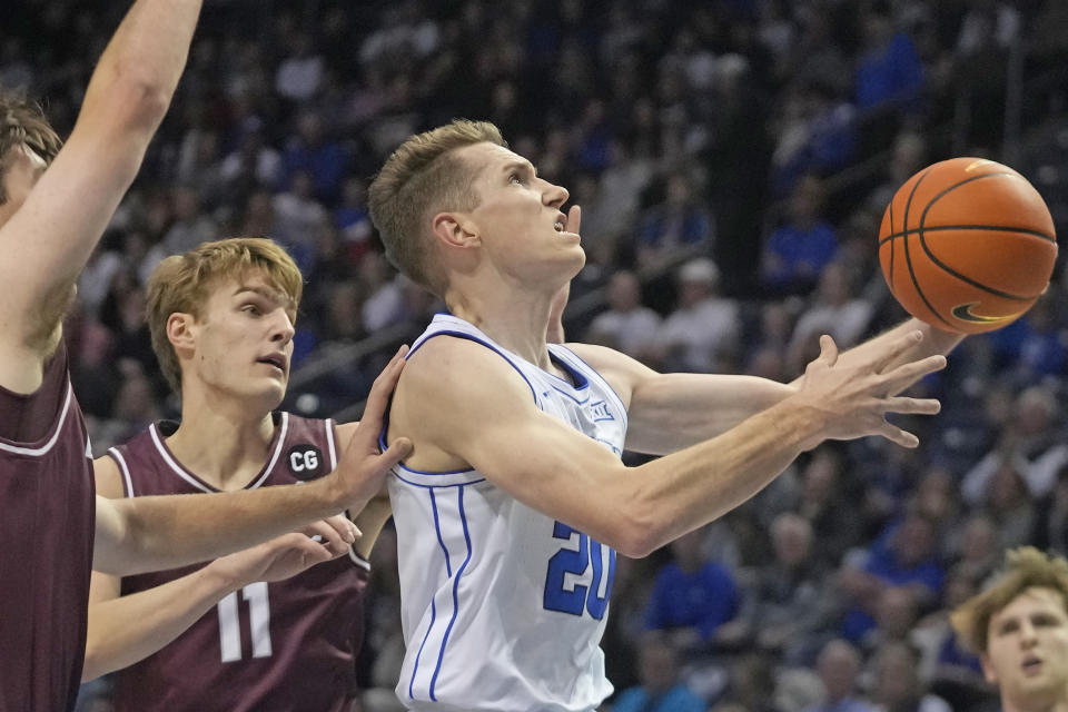 BYU guard Spencer Johnson (20) goes to basket as Bellarmine guard Billy Smith (11) defends during the first half of an NCAA college basketball game Friday, Dec. 22, 2023, in Provo, Utah. (AP Photo/Rick Bowmer)